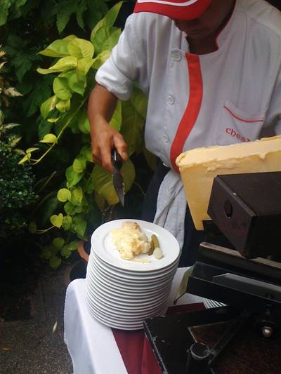 Raclette ย่างเนยแข็งให้ละลายแล้วเทลงบนจาน ที่ ร้านอาหาร Chesa Swiss Restaurant