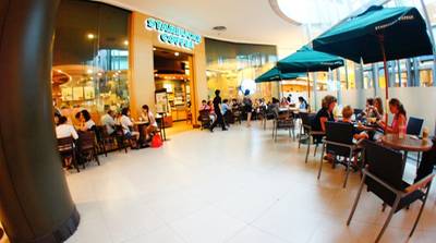 บริเวณด้านข้างของร้านที่มีโต๊ะเสริมด้านนอก สามารถรองรับคนได้จำนวนมาก ที่ ร้านอาหาร Starbucks Siam Paragon