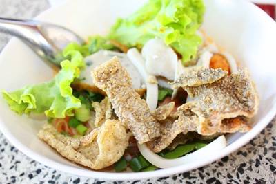 จะให้ดีต้องบุบหนังปลาซัลมอนทอดกรอบลงไปด้วย ที่ ร้านอาหาร เซี๊ยะก๋วยเตี๋ยวปลา