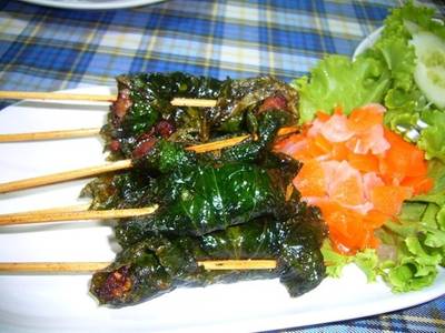 หมูห่อใบชะพลู ดูภายนอกคลายกับหมูย่างสเต๊ะ แต่กินเข้าไปแล้วรสชาติจะต่างกัน เสริฟพ ที่ ร้านอาหาร หนองคาย เสนา (ป้าสุ) ถนนพหลโยธิน