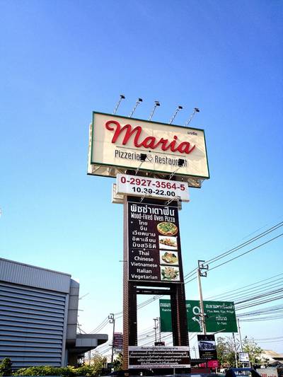 ป้ายขนาดใหญ่หน้าร้านริมถนน เห็นเด่นแต่ไกล ที่ ร้านอาหาร Maria Pizzeria & Restaurant