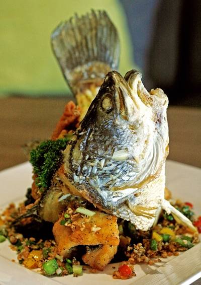 ปลากระพงคั่วแห้งพริกไทยดำและกระเทียม ที่ ร้านอาหาร Buri Tara Wine Bar & Restaurant